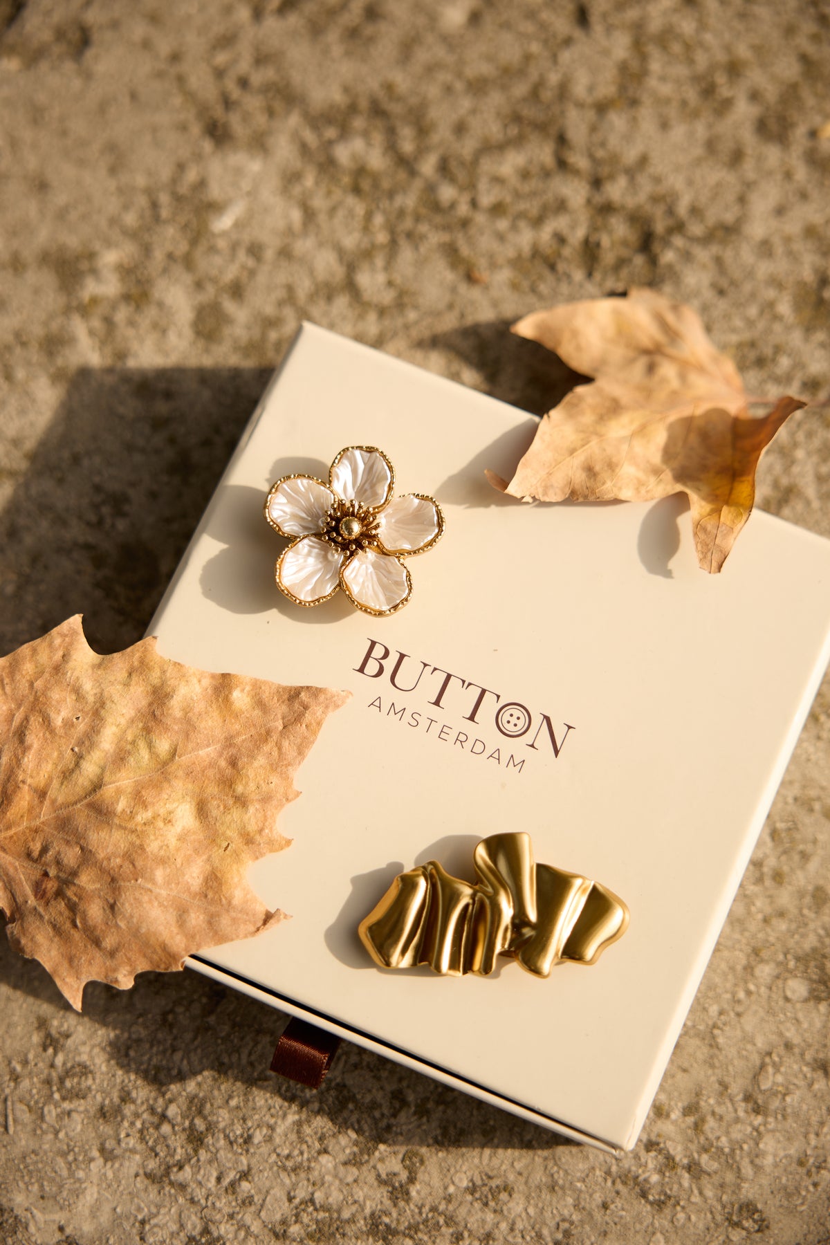 Gold magnetic brooch worn on a Button Amsterdam styled outfit